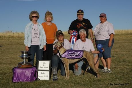 A group of people standing around a dog.